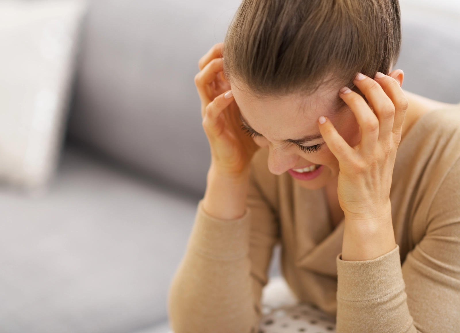 Impulse Control and Addiction Disorders: A woman holding her head with both hands.